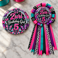 butterfly themed personalized birthday button and ribbon mum displayed on a marble tabletop