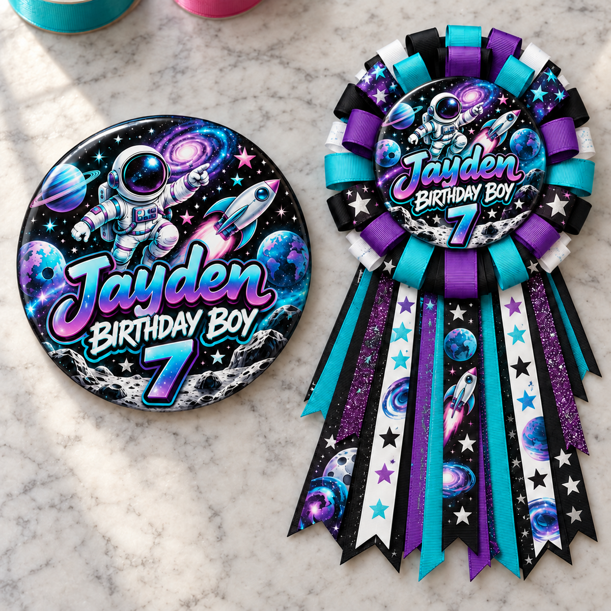 space themed personalized birthday button and ribbon mum displayed on a marble tabletop